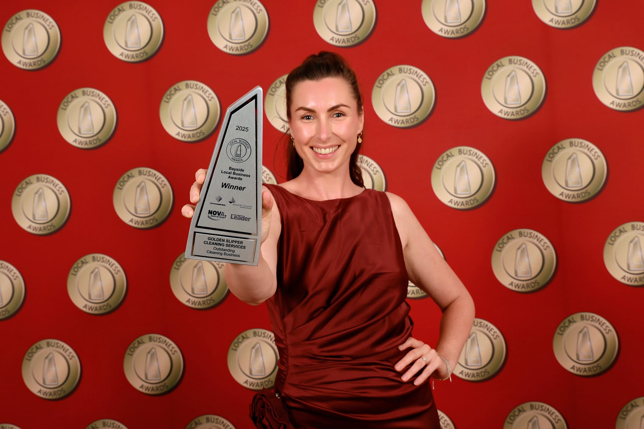 Abbie, founder of Golden Slipper Cleaning Services, holding the 2025 Bayside Local Business Awards trophy